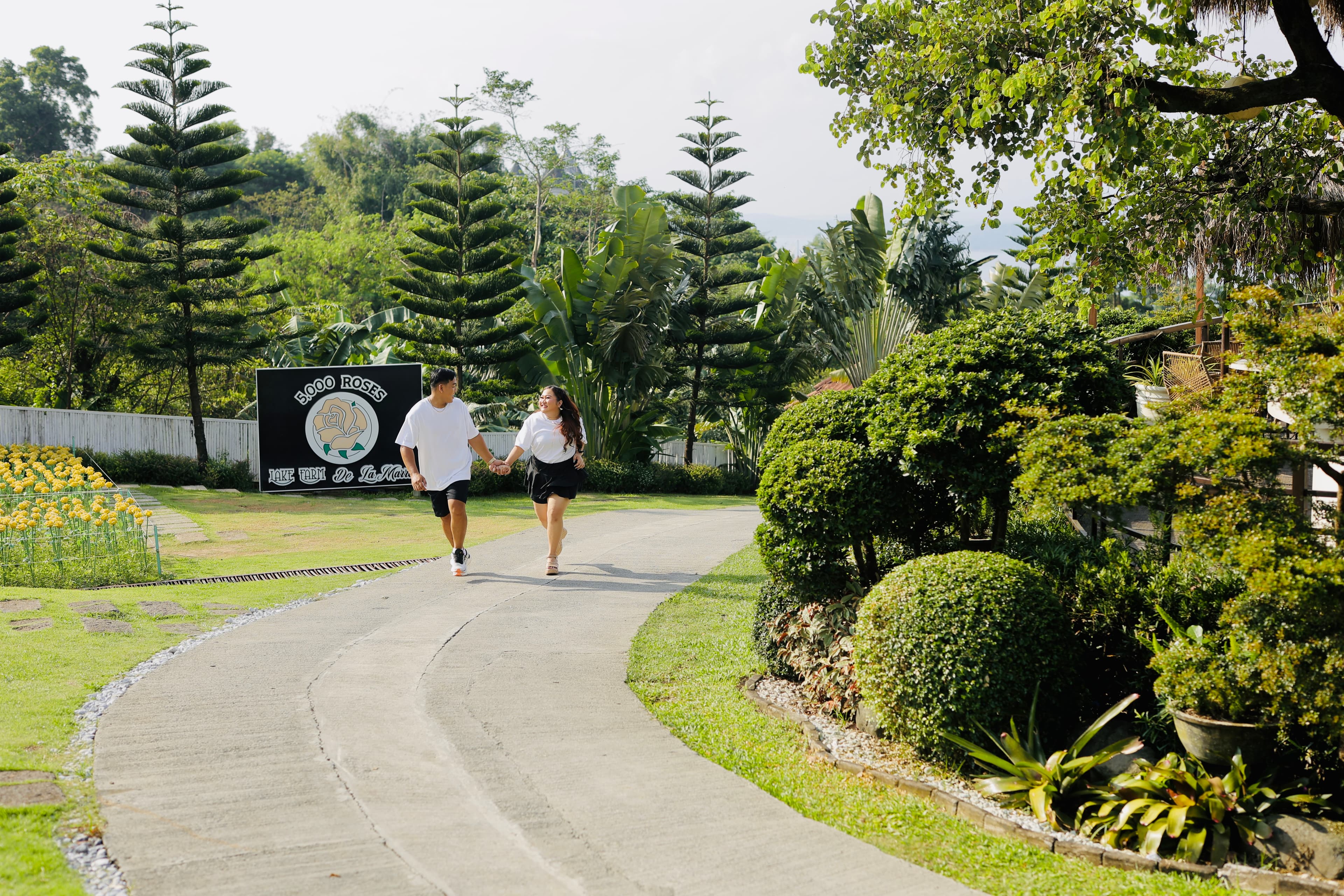 Mardy and Mayumi walking hand in hand along a garden path