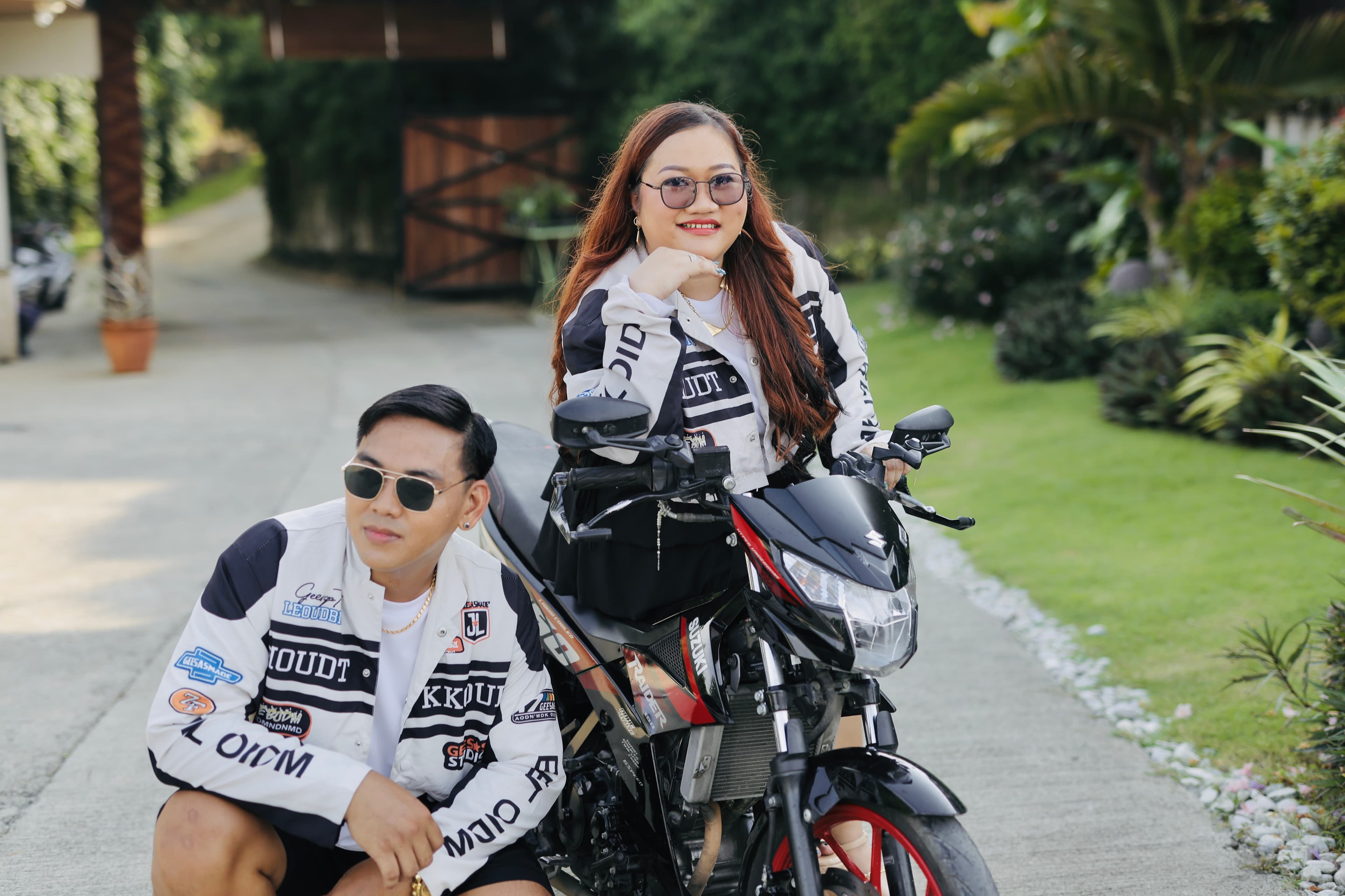 Mardy and Mayumi posing with their motorcycle in matching jackets